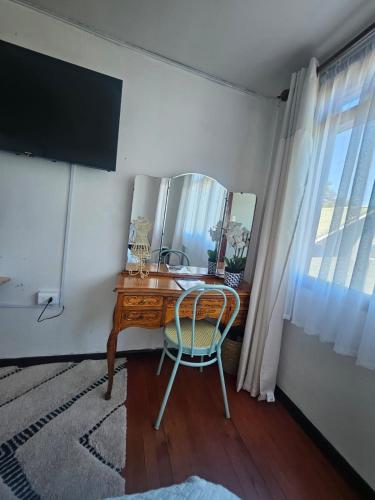 a desk with a mirror and a chair in a room at Casa Terra, Tu Refugio en la Naturaleza del Sur de Chile in Puerto Montt