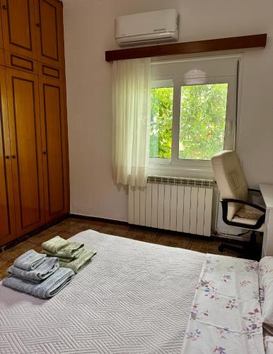 a bedroom with a bed and a chair and a window at Lemon tree's house in Kalavárda