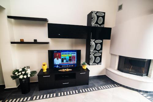 a living room with a tv and a fireplace at Koni Guesthouse in Kos Town