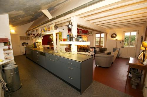 - une cuisine avec un long comptoir dans une pièce dans l'établissement Villa de charme entre deux baies, à Rue