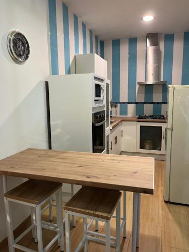 a kitchen with a wooden table and a refrigerator at White-Moon in Baena