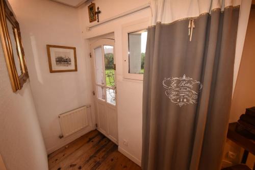 a hallway with a shower curtain and a window at Villa de charme entre deux baies in Rue