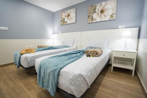 two beds in a room with blue walls at Terrazza Luxury Costa Adeje in Adeje