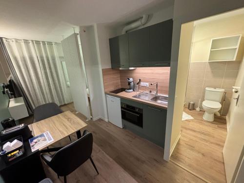 La cuisine est équipée d'une table, d'un lavabo et de toilettes. dans l'établissement Le D'Artagnan - App 10 - Balcon, à Cazaubon