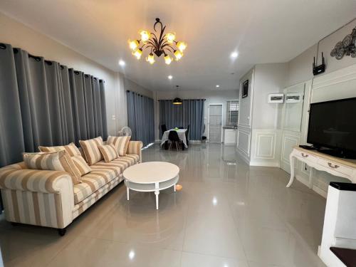 a living room with a couch and a table at Memories Of House in Ban Po Mo