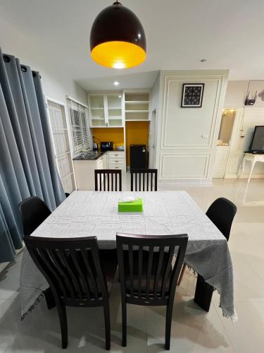 a dining room with a table and chairs and a kitchen at Memories Of House in Ban Po Mo