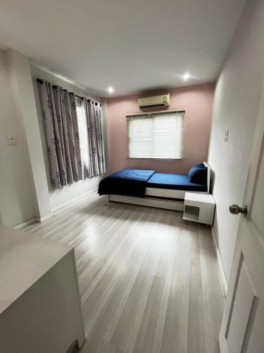 a bedroom with a bed and a window in a room at Memories Of House in Ban Po Mo