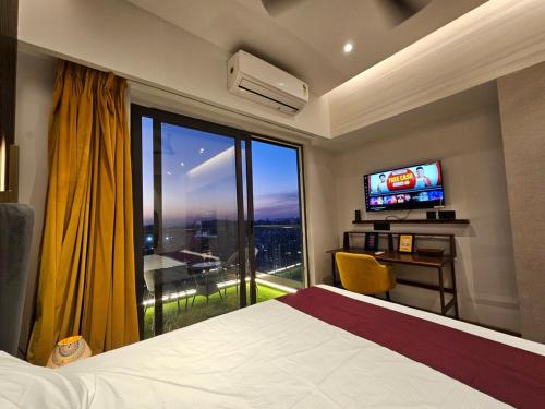 ガーズィヤーバードにあるVelvet Stays City Top View Luxury Staycationのベッドと大きな窓があるホテルの部屋