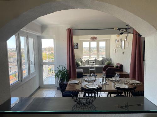 - un salon avec une table et des verres à vin dans l'établissement Spacieux T4 tout confort, vue sur Bordeaux, à Mérignac