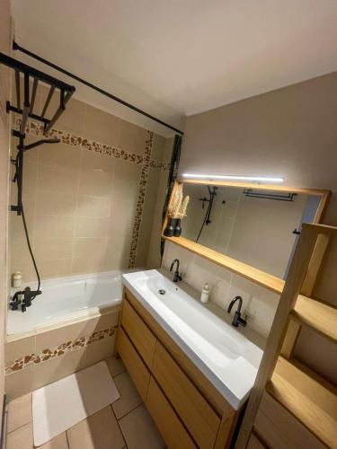 une salle de bain avec une baignoire et un lavabo et une baignoire dans l'établissement Spacieux T4 tout confort, vue sur Bordeaux, à Mérignac