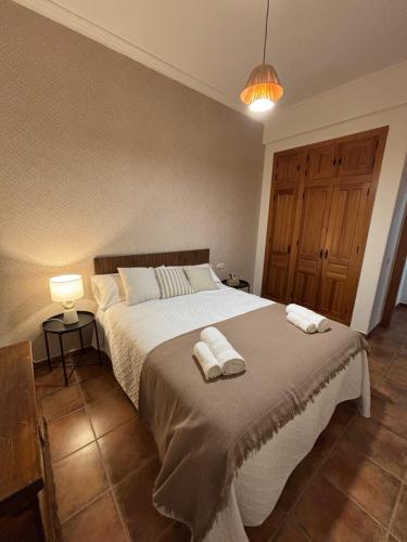 a bedroom with a large bed with two towels on it at REFUGiO MAGiCO in Herencia