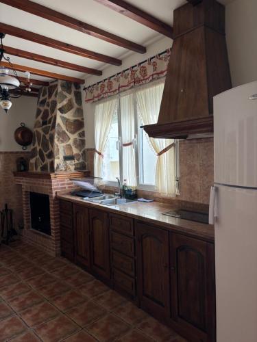 a kitchen with a refrigerator and a sink and a fireplace at REFUGiO MAGiCO in Herencia