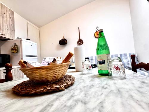 a table with a basket of bread and a green bottle at Vicolo della Quiete Anagni in Anagni