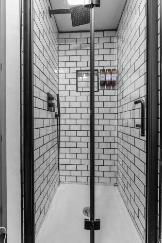 a bathroom with a shower with white tile walls at 15 to Foxwoods, 20 Mohegan Lake & Casino Escape in Glasgo