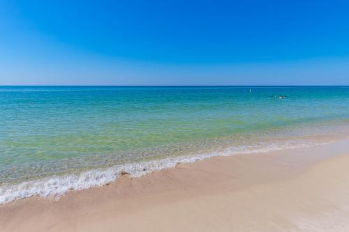 a sandy beach with the ocean in the background at Phoenix All Suites West Hotel in Gulf Shores