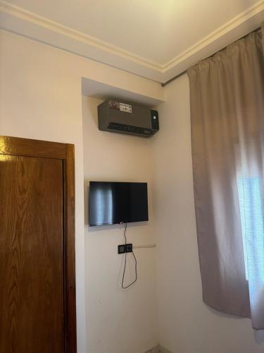 a room with a television on the corner of a wall at Chic and comfortable air-conditioned apartment in Fès