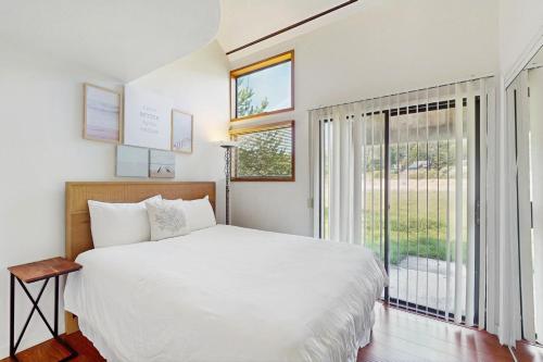 a bedroom with a white bed and a large window at One Eyed Jack's Retreat in Sea Ranch