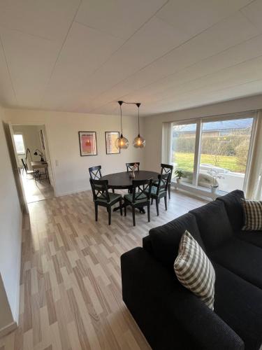 a living room with a black couch and a table at Casa Egevænget - 400 meters to LEGO HOUSE and Shopping in Billund
