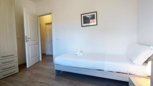 a white bedroom with a large bed and a desk at Santa Caterina in Levanto