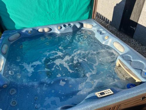 a jacuzzi tub filled with water with a thermometer in it at The Follonsby hot tub Retreat with own bar near city centre in Gateshead