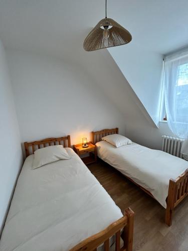 deux lits jumeaux dans une chambre avec fenêtre dans l'établissement La maison du Distillateur, à Plurien