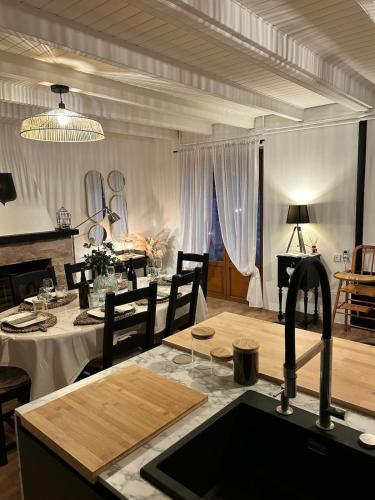 - une cuisine et une salle à manger avec une table et un évier dans l'établissement La maison du Distillateur, à Plurien