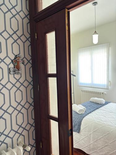 a bedroom with a bed and a door with a mirror at REFUGiO MAGiCO in Herencia