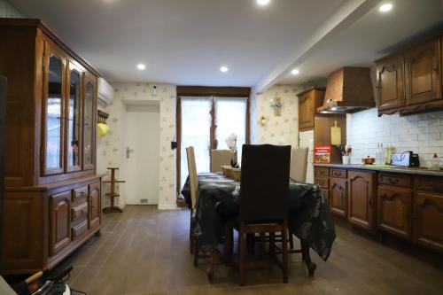 une cuisine avec une table et des chaises dans l'établissement petite maison dans village de caractére, à Vignory
