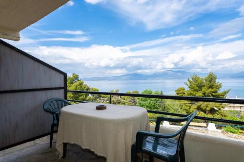 a table on a balcony with a view of the water at Oropos By the Sea in Markópoulon Oropoú