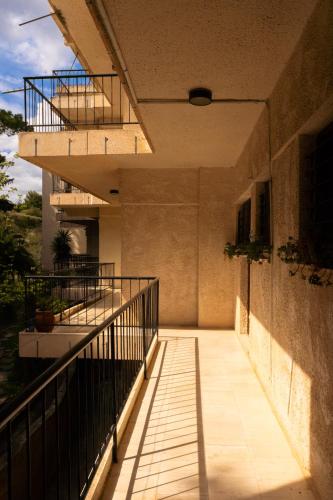 a balcony of a building with a staircase at Oropos By the Sea in Markópoulon Oropoú