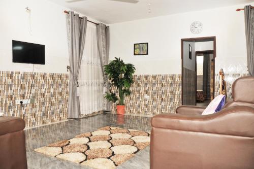 a living room with two chairs and a rug at Large Stylish 2 Bedroom Flat in Kumasi