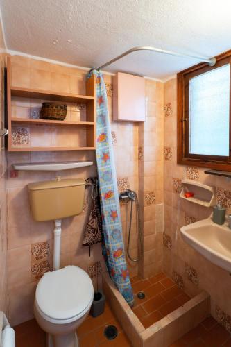 a small bathroom with a toilet and a sink at Oropos By the Sea in Markópoulon Oropoú