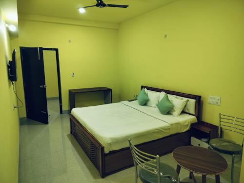 a bedroom with a bed and a table and chairs at Hotel Golden Buddha Inn Bodhgaya in Bodh Gaya