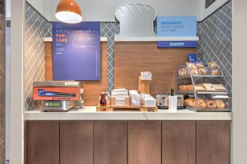 a bakery counter with donuts and a cash register at Holiday Inn Express - Dallas Downtown by IHG in Dallas