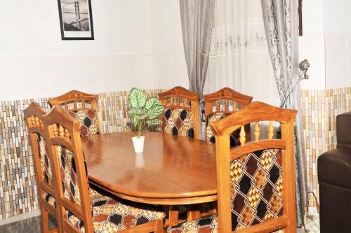 a dining room table and chairs with a plant on it at Large Stylish 2 Bedroom Flat in Kumasi