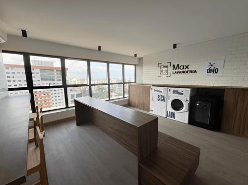 a large room with a desk and a microwave at Max Derby - Studios no Centro do Recife por Yolo in Recife