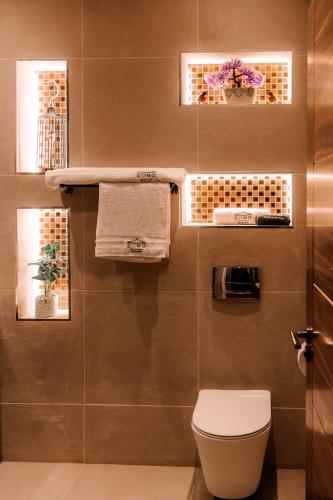 a bathroom with a toilet and some towels at Domo Boutique Hotel Birmingham in Birmingham