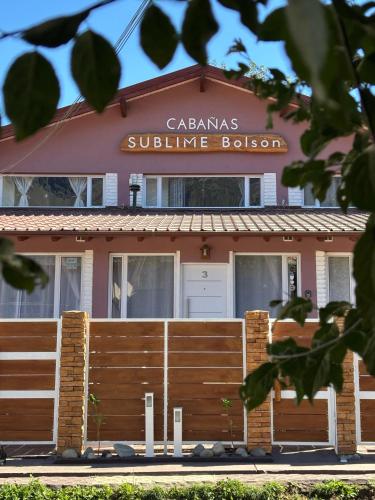a building with a fence in front of it at Cabañas Sublime Bolson in El Bolsón