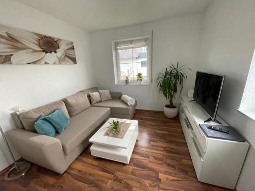 a living room with a couch and a flat screen tv at Melli‘s Seenahe Ferienwohnung in Langenargen
