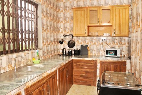 a kitchen with wooden cabinets and a sink at Large Stylish 2 Bedroom Flat in Kumasi