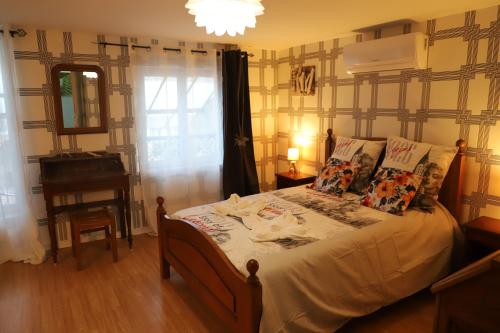 a bedroom with a bed with pillows and a piano at petite maison dans village de caractére in Vignory