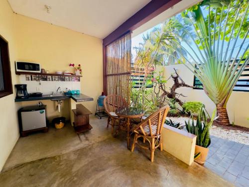 a living room with a table and chairs and a large window at Casa Majagua in Brisas de Zicatela