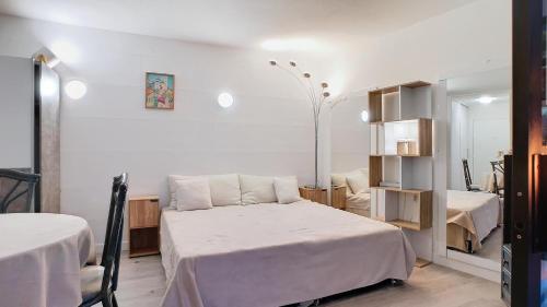 une chambre avec un lit blanc et un miroir dans l'établissement Appartement élégant proche de la plage, à Mandelieu-la-Napoule