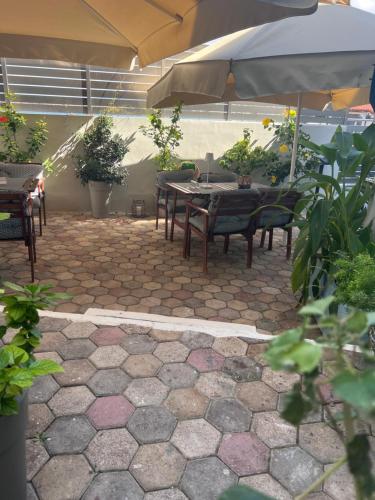 a patio with tables and chairs and an umbrella at Sea Breeze in Kalamaki Chanion
