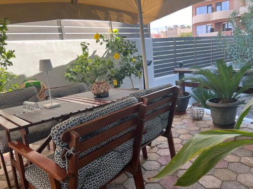 a patio with a table and chairs and plants at Sea Breeze in Kalamaki Chanion