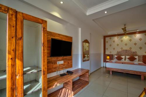 a bedroom with a bed and a television in a room at Hotel Sea Sapphire ,Calangute in Calangute