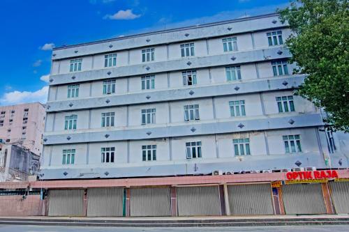 a white building with a fence in front of it at Townhouse Oak Palembang Near Jembatan Ampera Formerly Azzura Hotel in Palembang