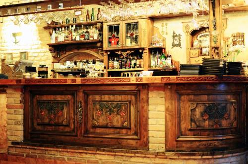 a bar with wooden cabinets and bottles of alcohol at Gabi B&B in Vilnius