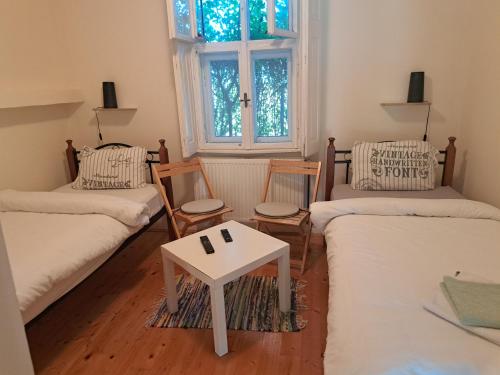 a living room with two beds and a table at Salaš Đorđević in Subotica