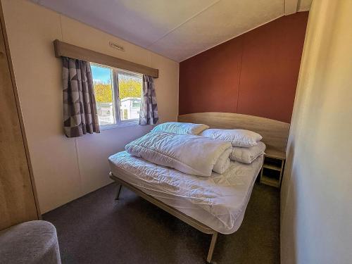 BenacreにあるHomely Caravan At Kessingland Beach Holiday Park, Suffolk Ref 90040Bcの窓のある小さな部屋にベッドが2つある